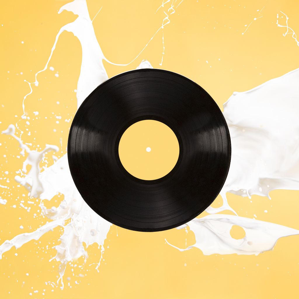 Черная пластинка с белой краской на желтом фоне