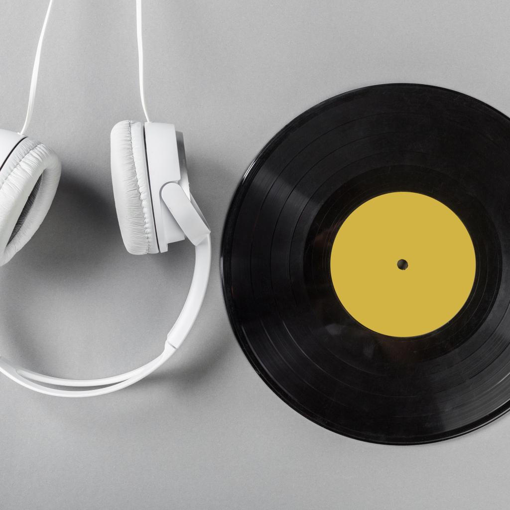 Черная пластинка и наушники на сером фоне