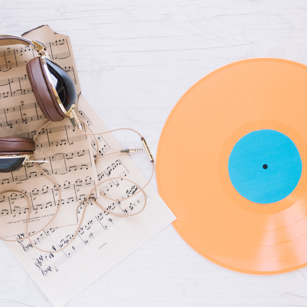 Наушники, ноты и виниловая пластинка на белом фоне