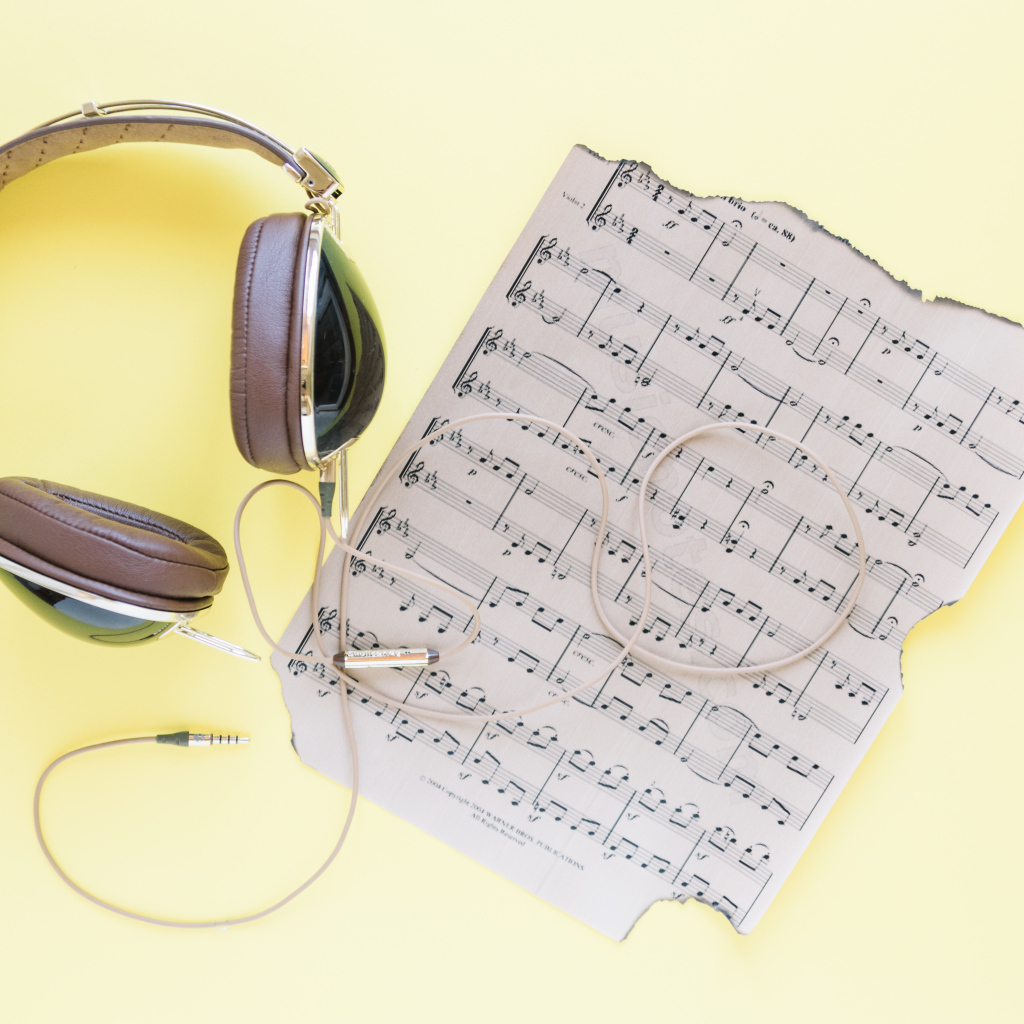 Старые ноты и наушники на желтом фоне