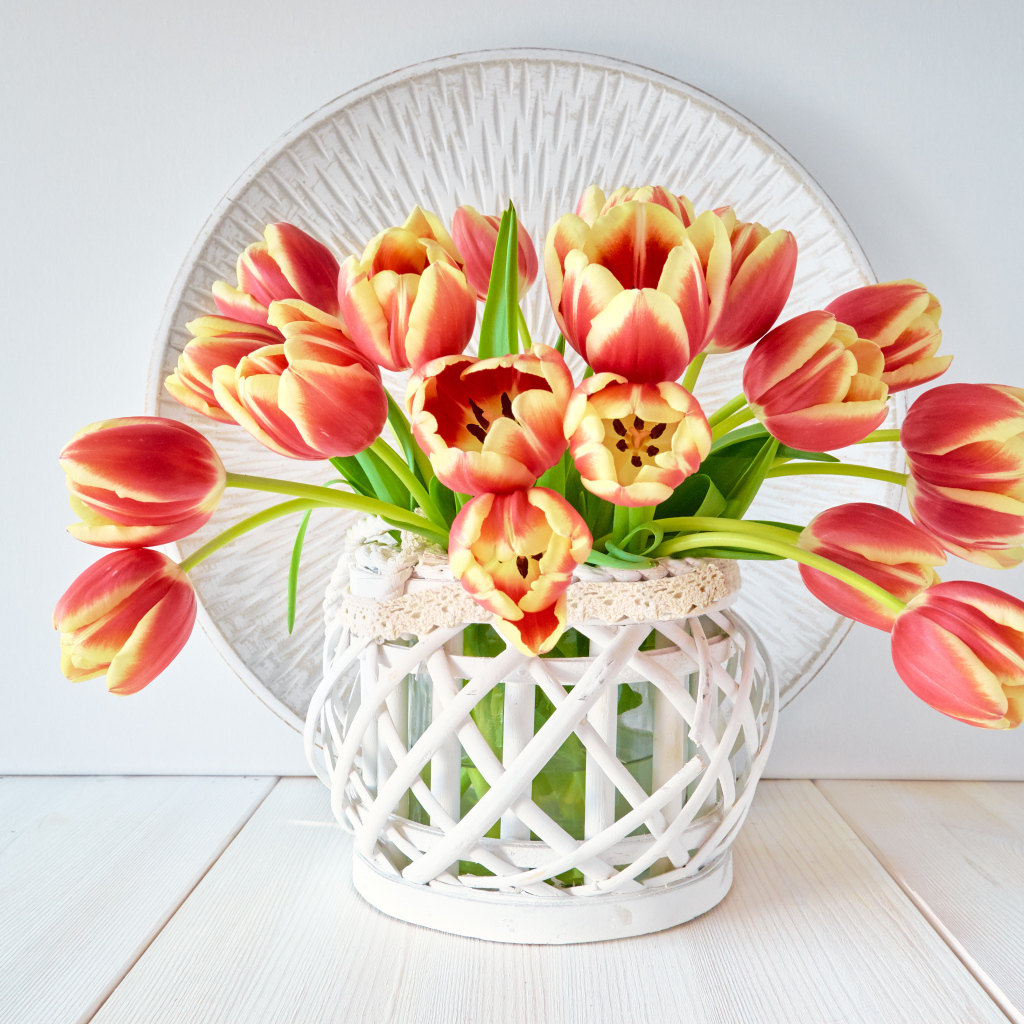 Красивый букет оранжевых тюльпанов в белой вазе на столе