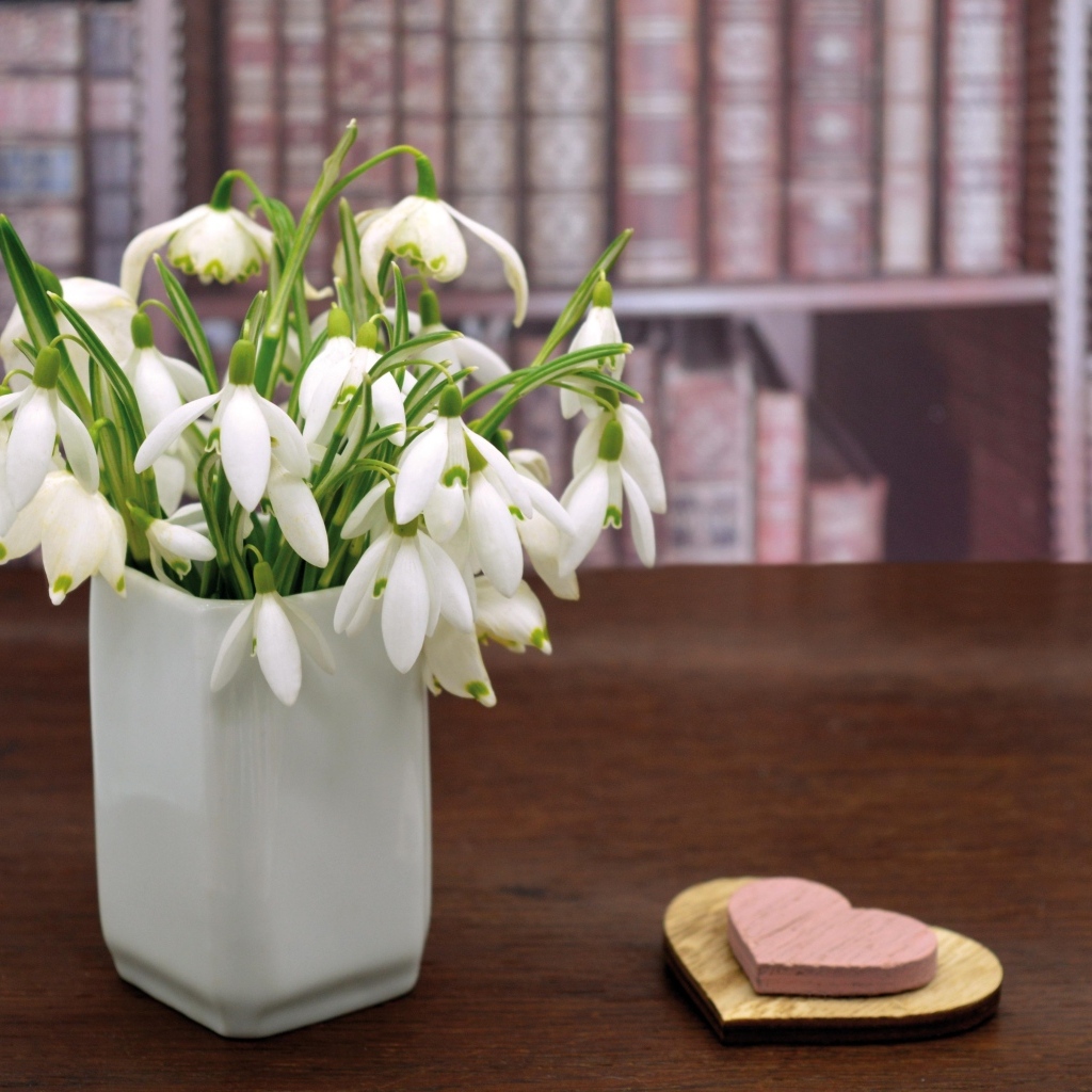 Букет белых подснежников в вазе на столе с сердечками