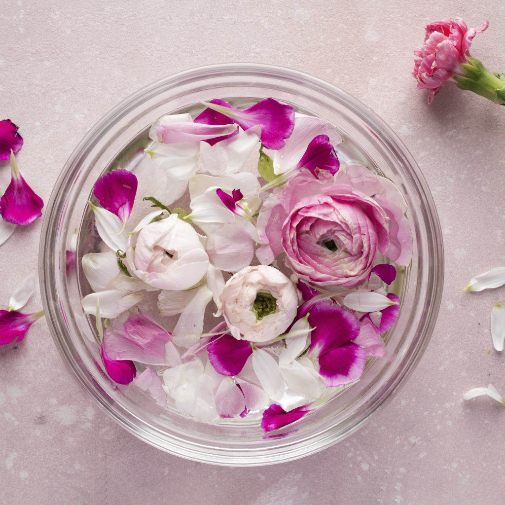 Стеклянный сосуд с оборванными цветами розы и лютика