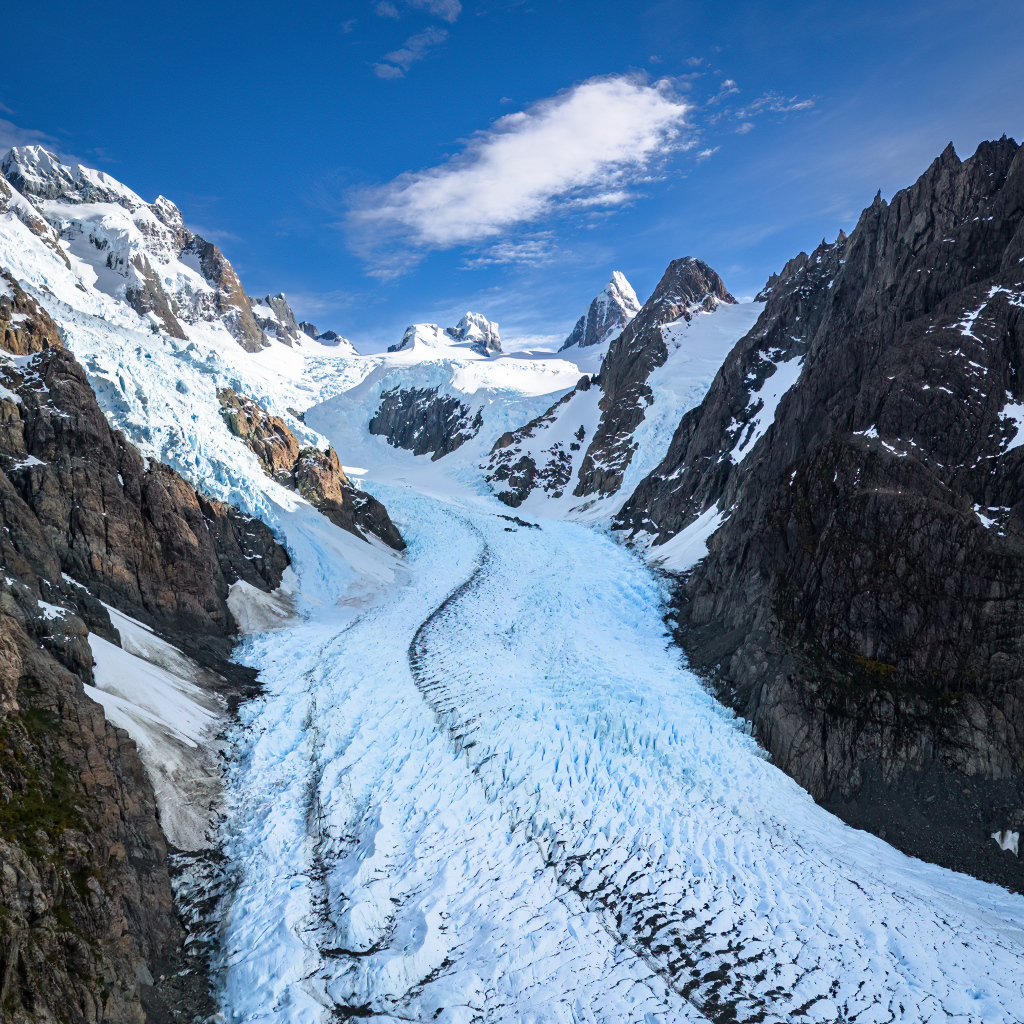 Заснеженная заледеневшая дорога между гор