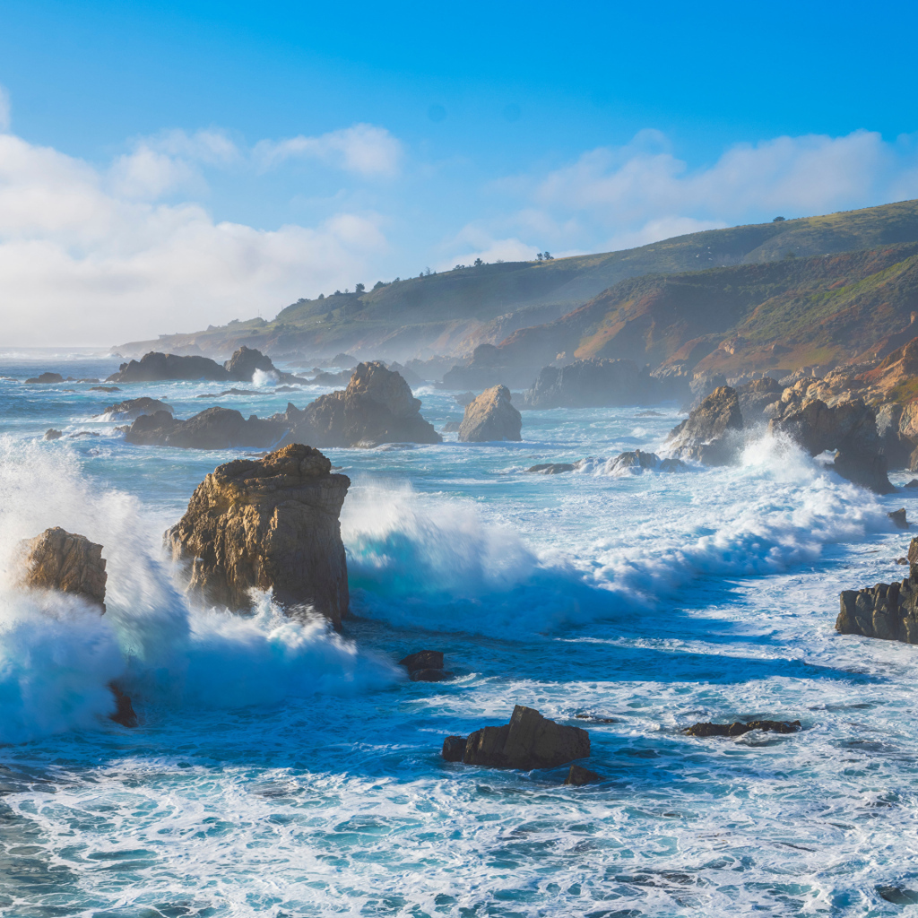 Белые бушующие волны бьются о камни 