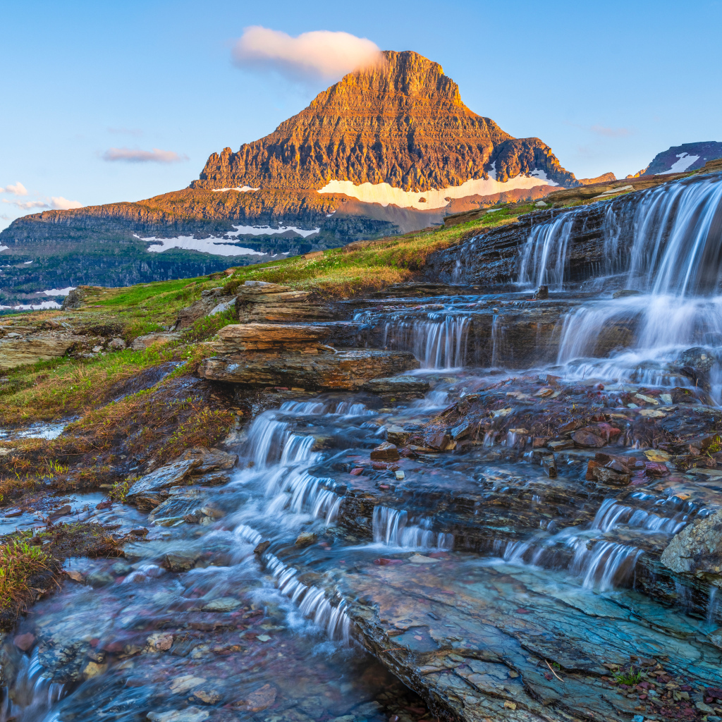 Водопад стекает по камням у высокой горы