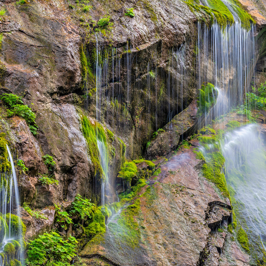 Водопад стекает по большим холодным камнях