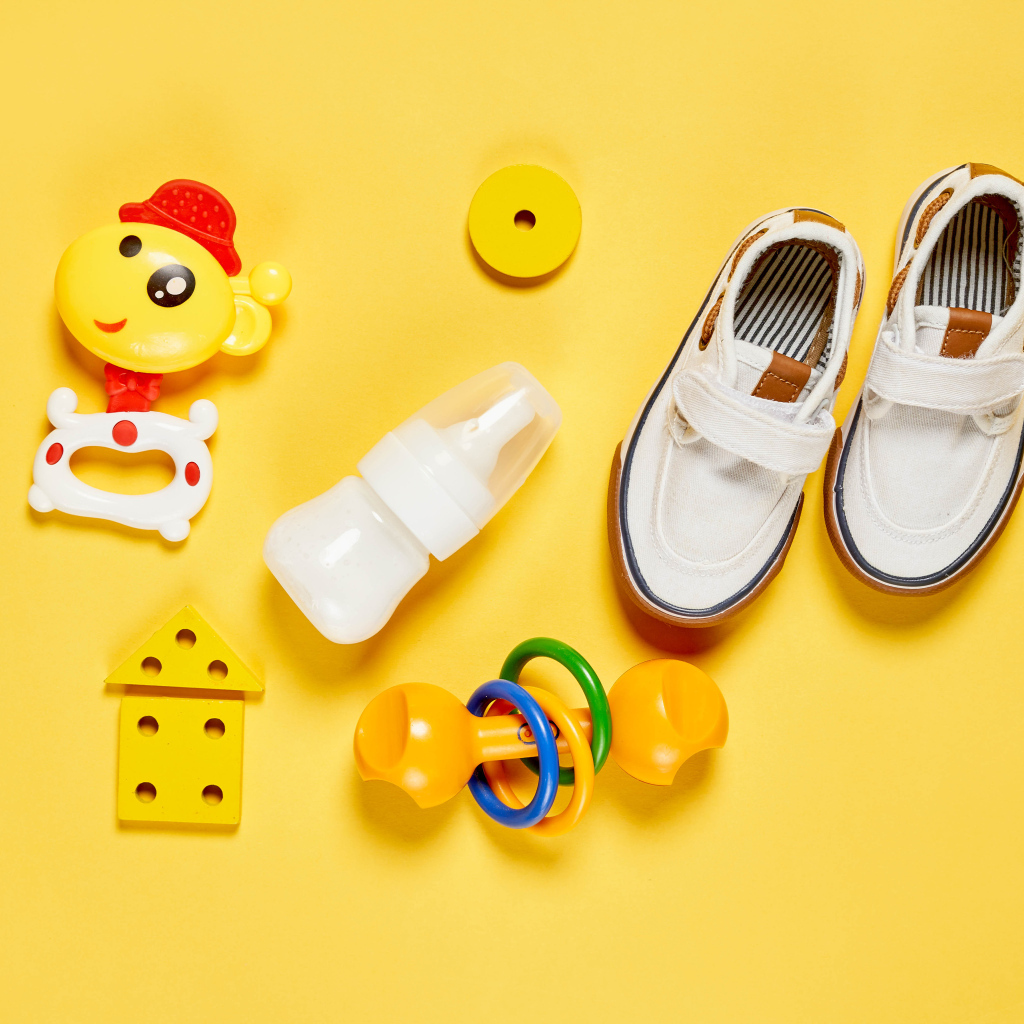 Детские игрушки и обувь на желтом фоне