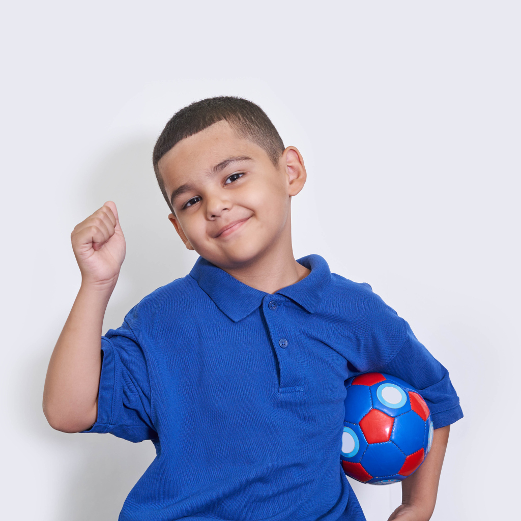 Милый мальчик с мячом на белом фоне