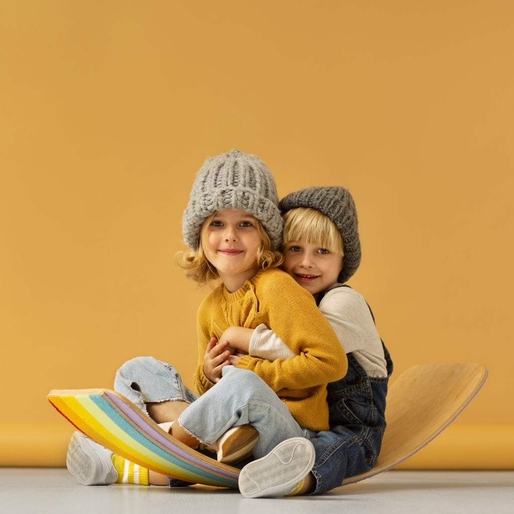 Счастливые брат и сестра в теплых шапках