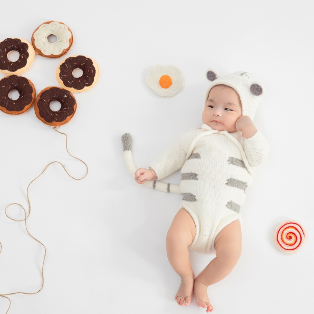 Маленький ребенок с игрушками в форме пончика