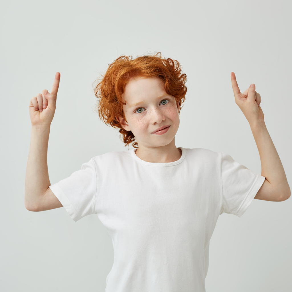 Рыжеволосый мальчик в белой футболке