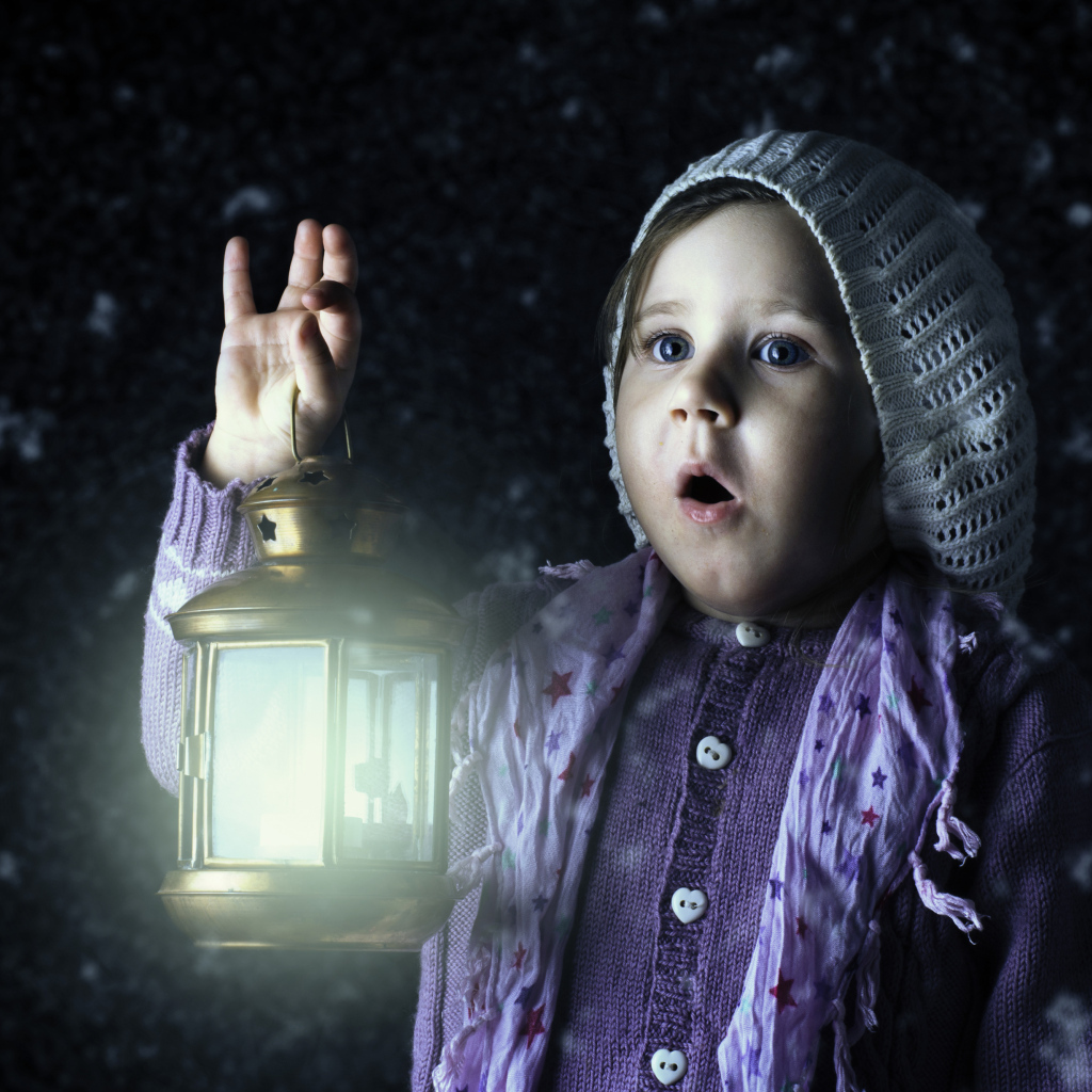 Удивленная маленькая девочка с фонарем в руках