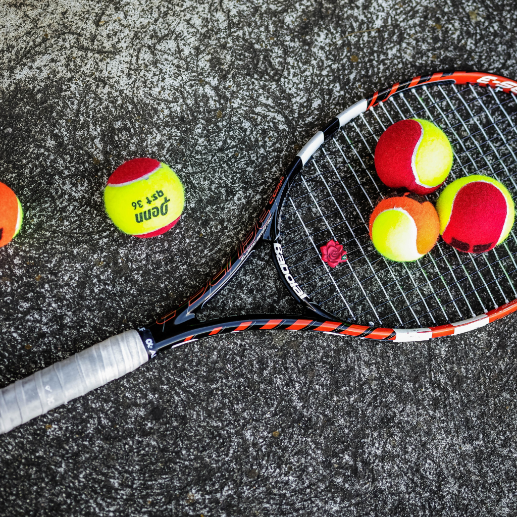 Ракетка и теннисные мячи на черном фоне