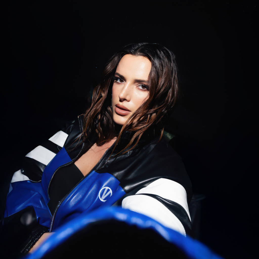 Актриса Белла Торн в кожаной куртке на черном фоне