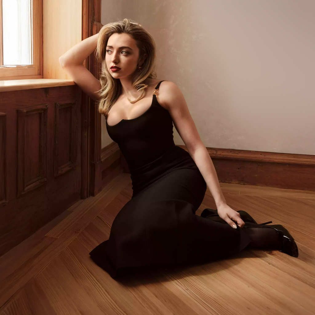 Актриса Пейтон Рой Лист в черном платье сидит на полу у окна