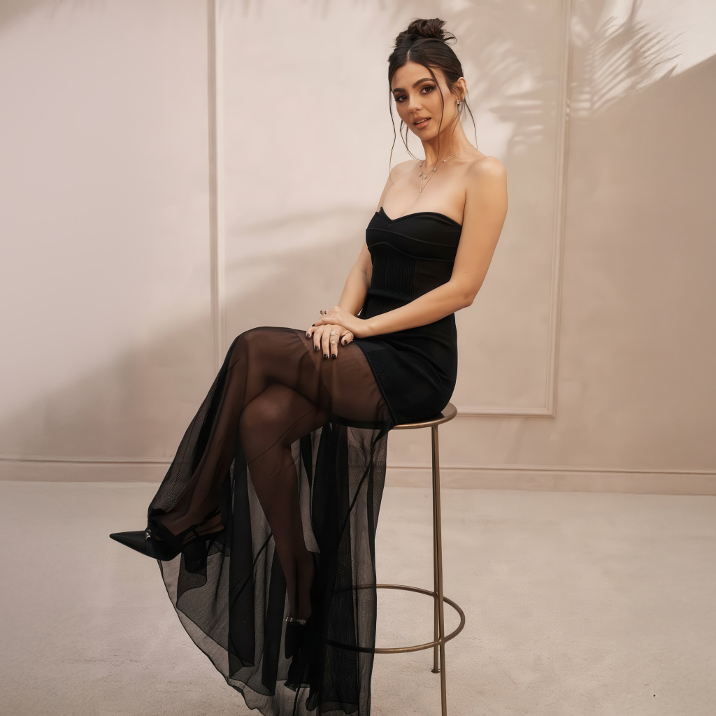 Американская актриса Виктория Джастис в черном платье на стуле