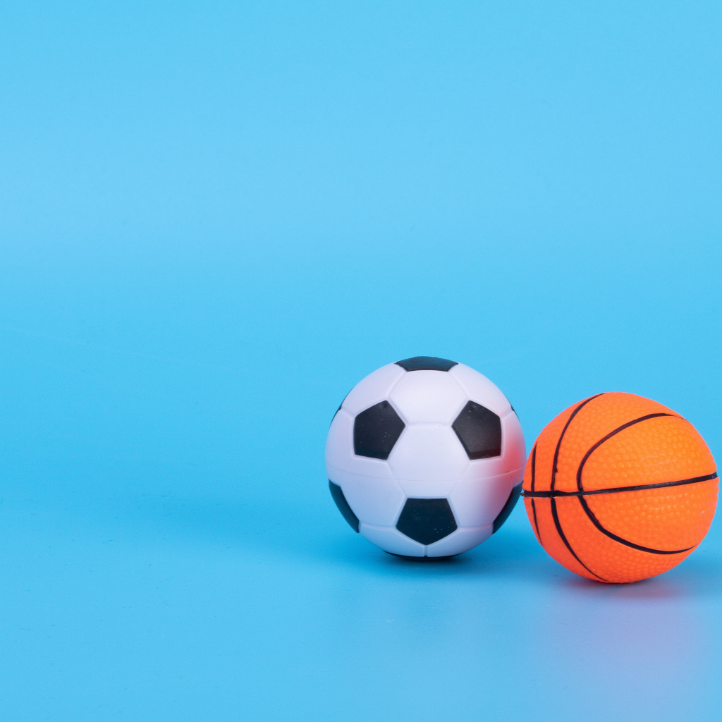 Футбольный и баскетбольный мяч на голубом фоне