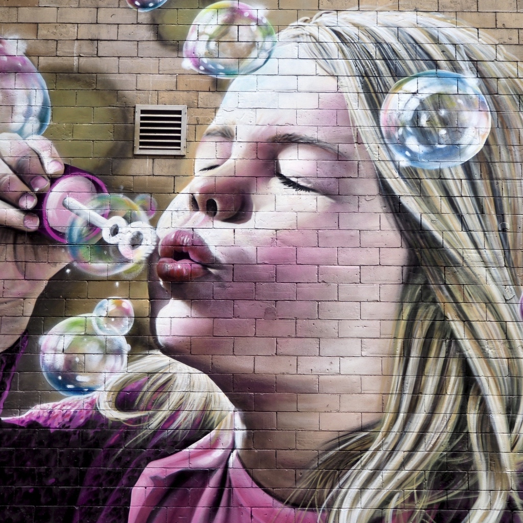 Нарисованная на стене маленькая девочка с мыльными пузырями