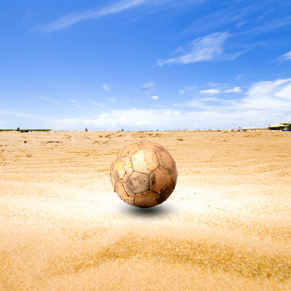 Старый футбольный мяч на песке