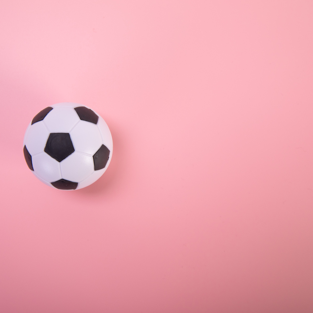 Футбольный мяч на розовом фоне