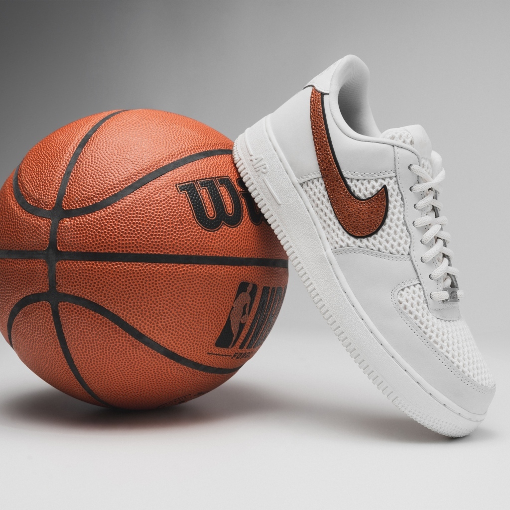 Спортивная обувь и баскетбольный мяч на сером фоне