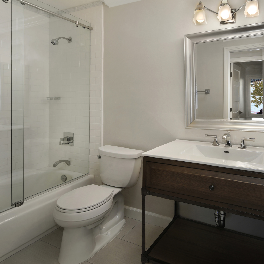 Интерьер ванной комнаты в белом цвете с душевой кабиной и унитазом