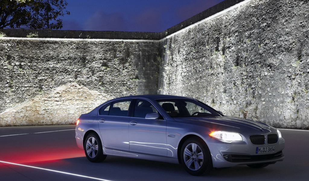 БМВ 5 серии окруженный стеной
