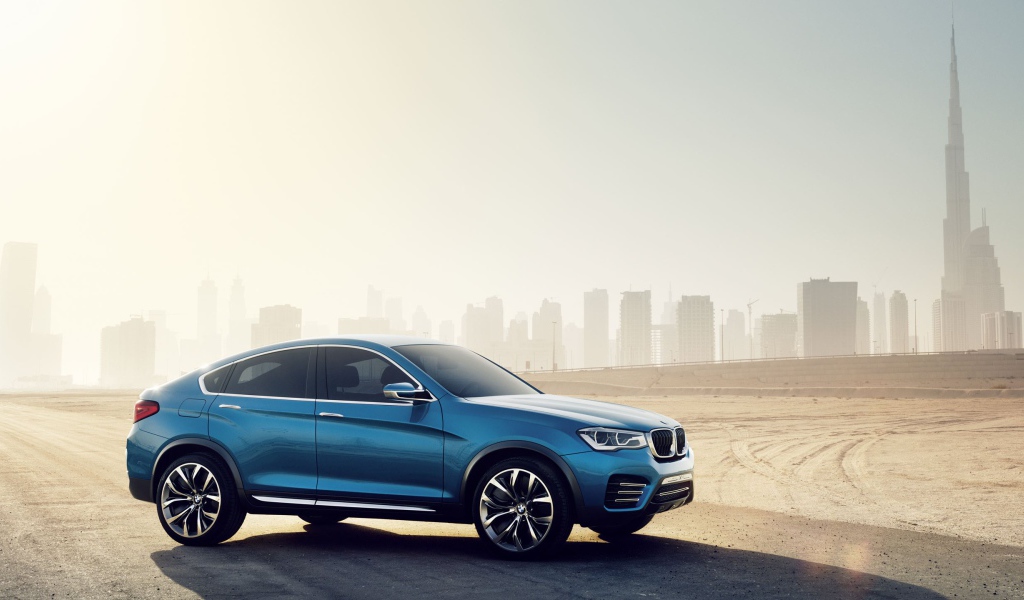 The blue BMW X4 crossover on the city landscape