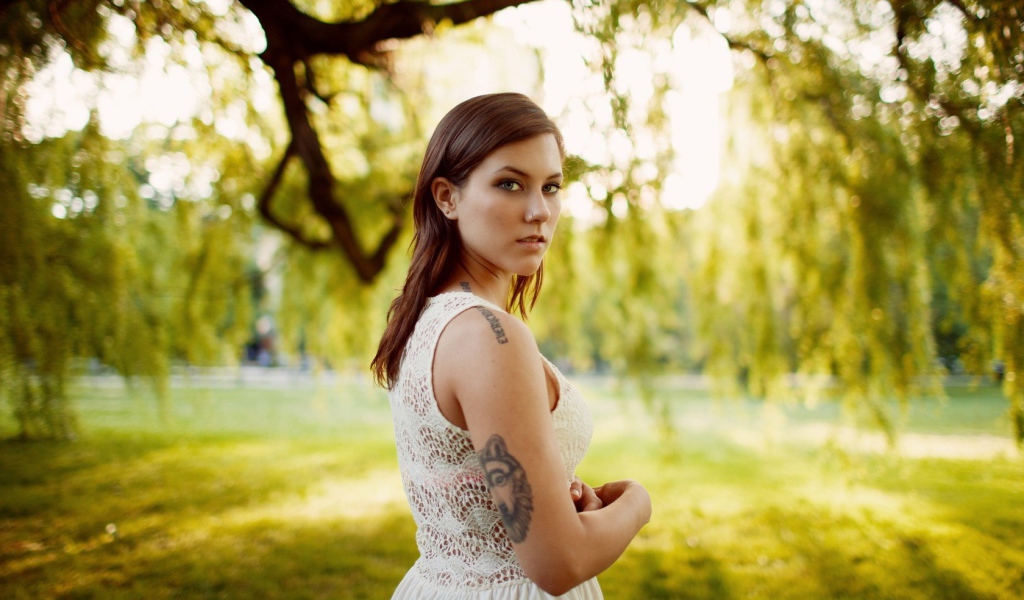 Брюнетка с татуировкой на природе