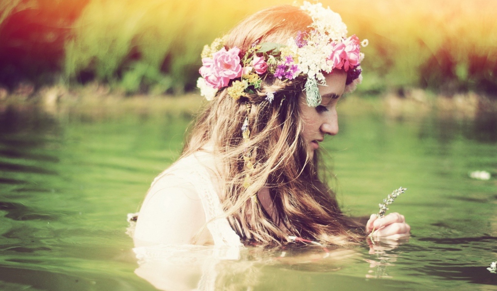 Девушка купается с венком на голове