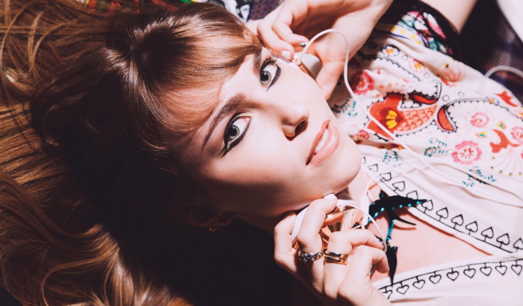 Девушка лежит с наушниками