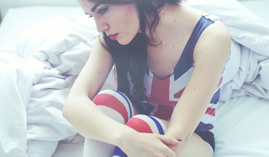 Девушка грустит на кровати