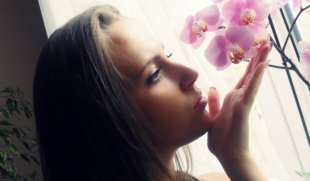Девушка смотрит орхидею