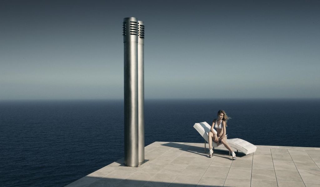 Девушка сидит у моря