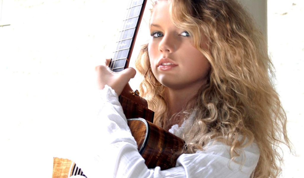 Taylor Swift обнимает свою гитару