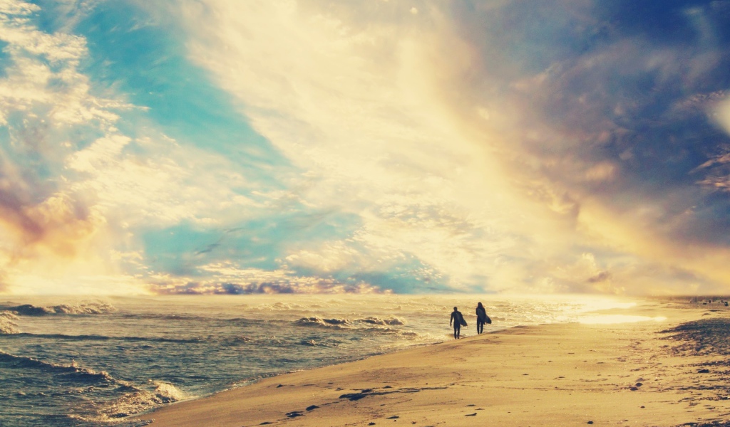 Двое идут по солнечному пляжу