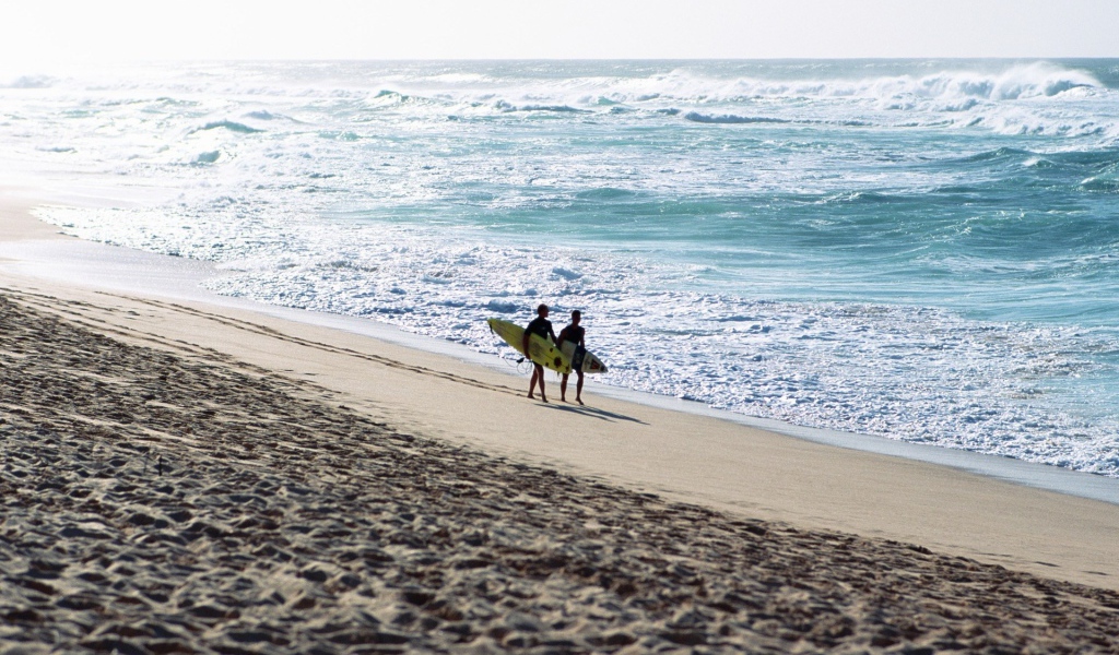 Два человека идут по пляжу