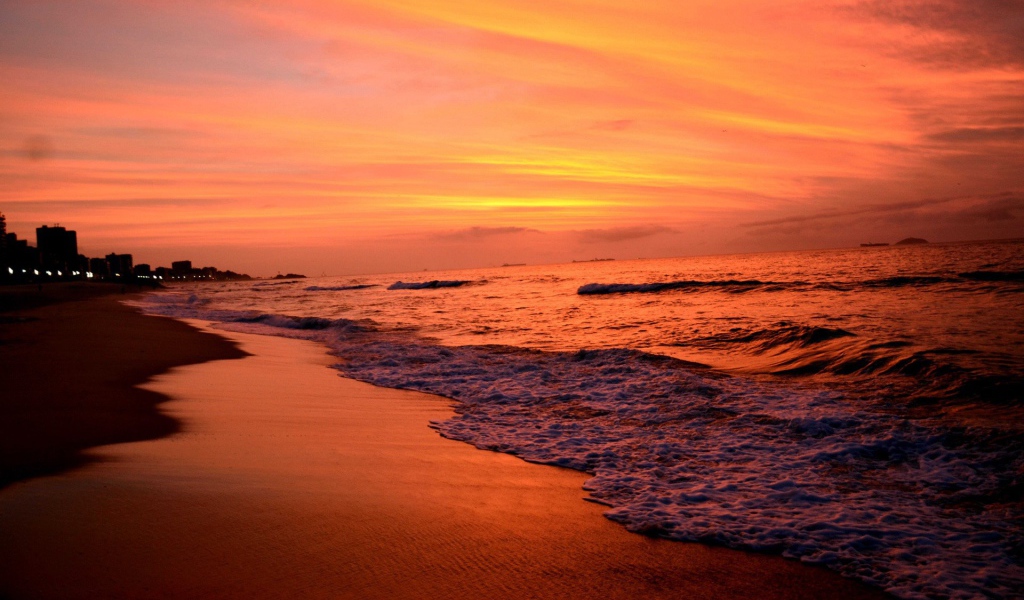 На закате волны лижут пляж