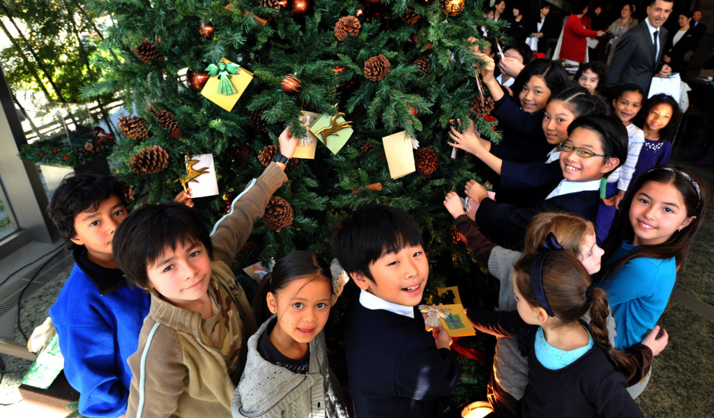 Дети рядом с новогодней елкой