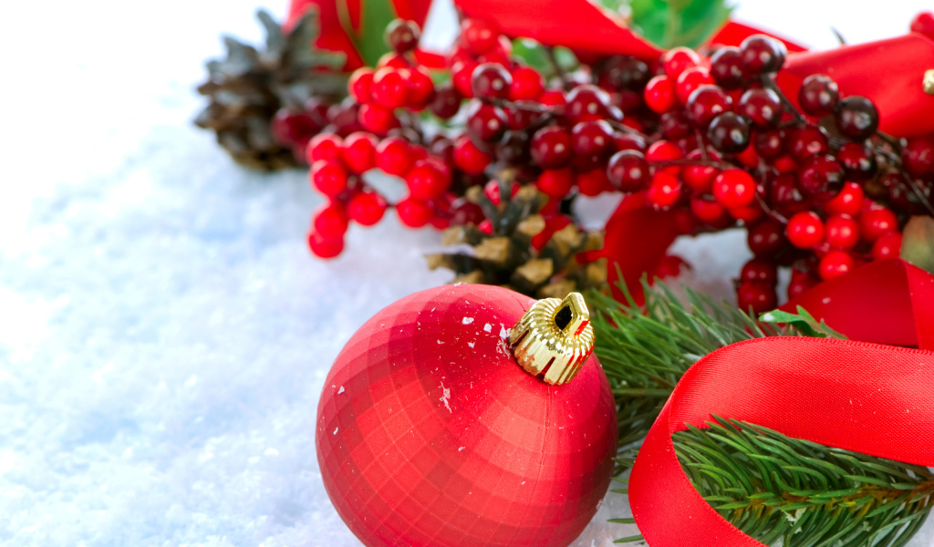 Красные ёлочные украшения на снегу