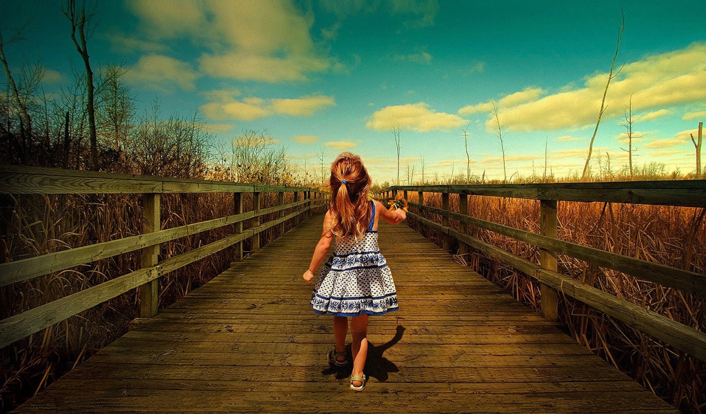 Девочка идет по деревянному мосту