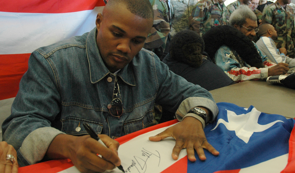Боксер Феликс Тринидад подписывает флаг
