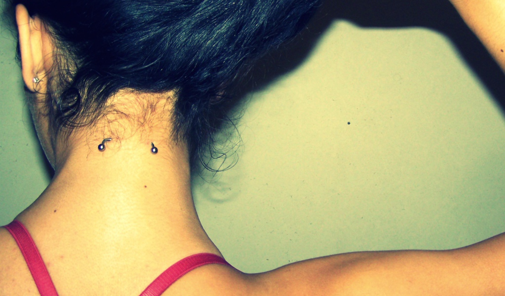 Девушка брюнетка с пирсингом в шее