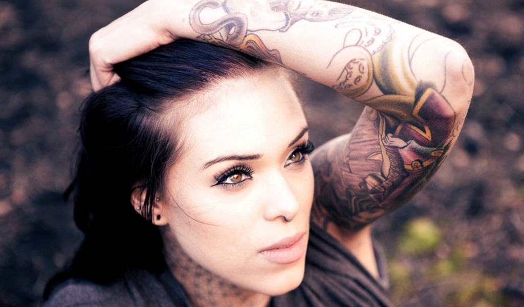 Девушка с цветной татуировкой на руке