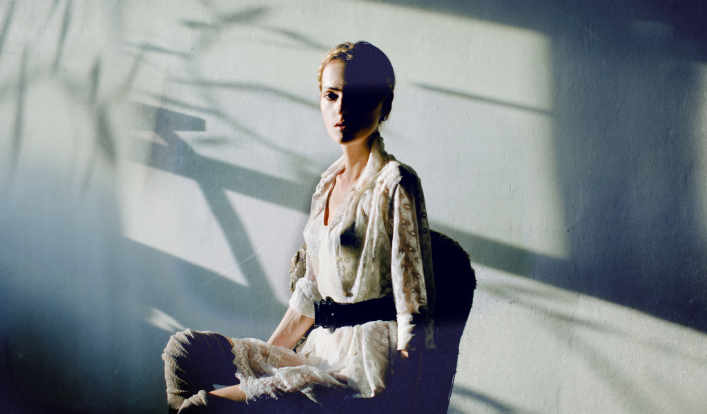 Фотография девушки на фоне белой стены