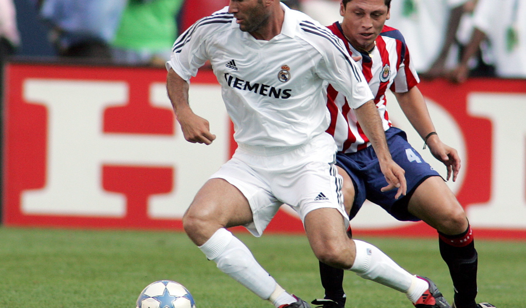 Легенда футбола Зинедин Зидан передавая мяч