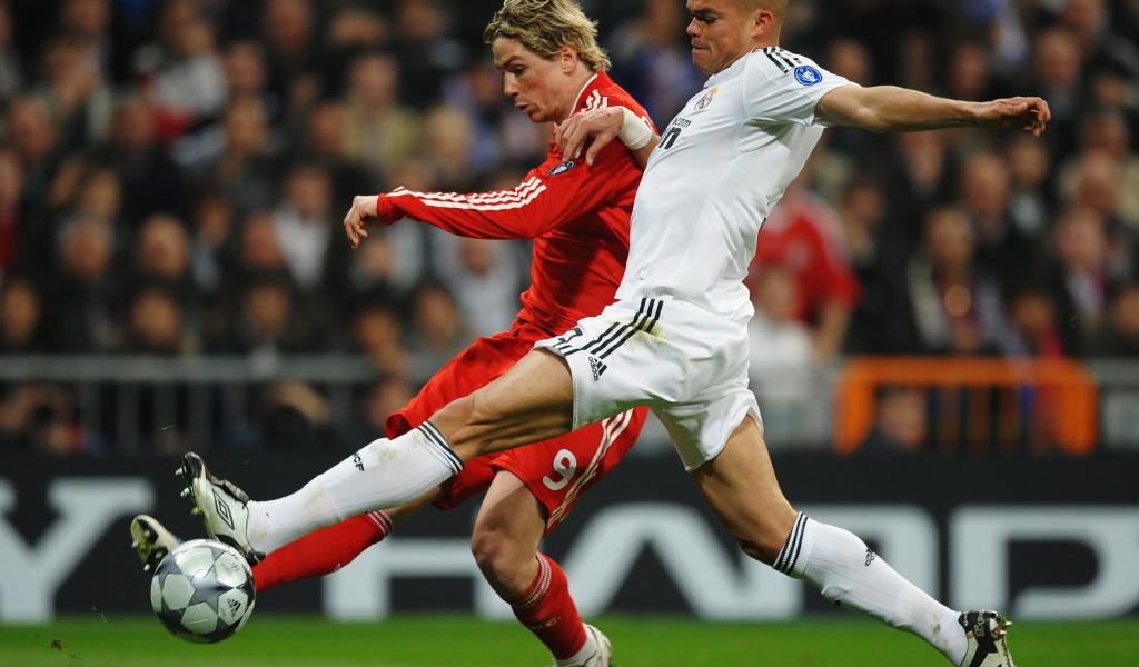 Игрок из Реал Мадрид Пепе пытается взять мяч