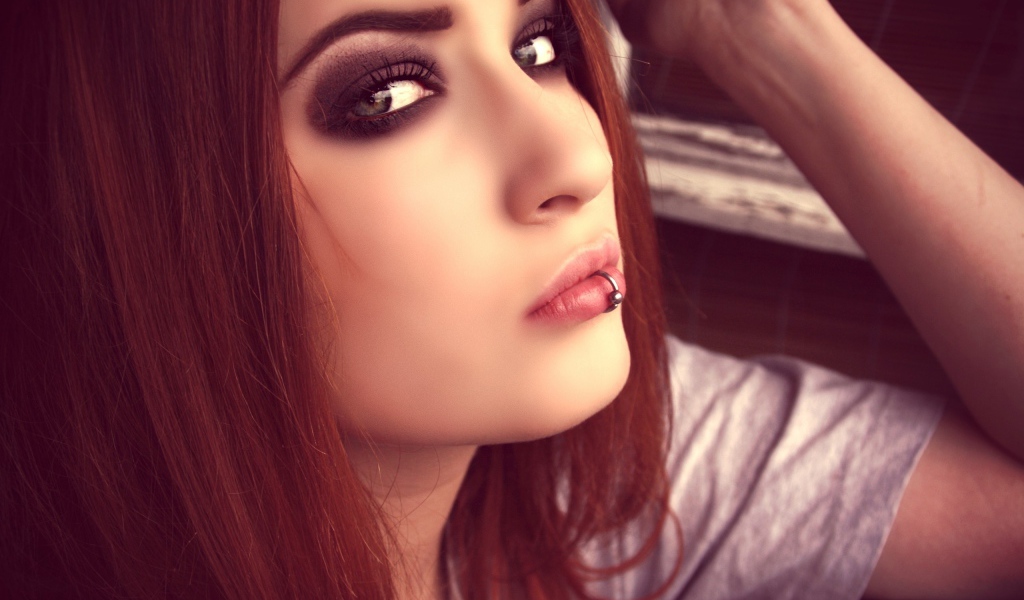 Молодая девушка шатенка с пирсингом в губе