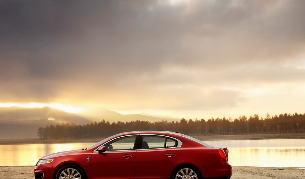 Красный автомобиль на берегу реки